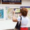 Billede af Exploré 8 med kvinde der holder den op foran et kort over metro