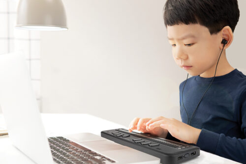 Billede af dreng med Brailliant BI 40X og computer